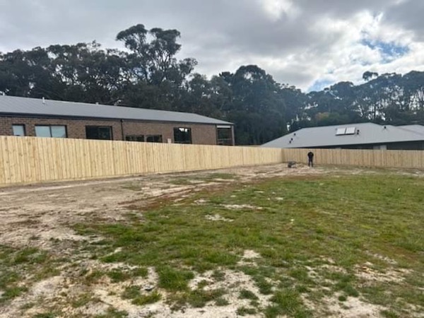 a timber paling fence along a grassed block