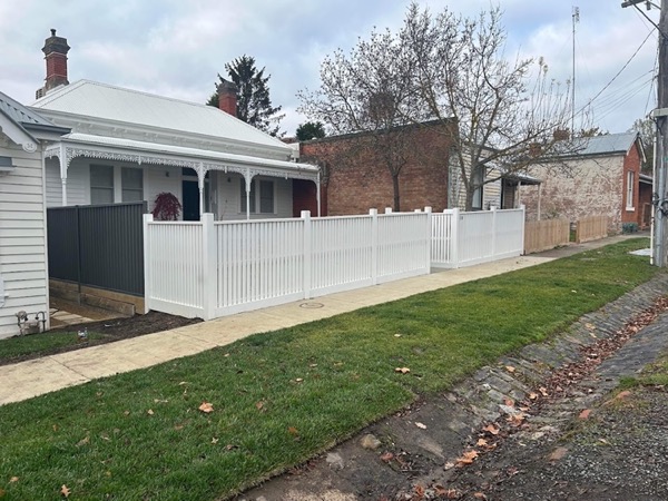 a white picket fence along a footpath