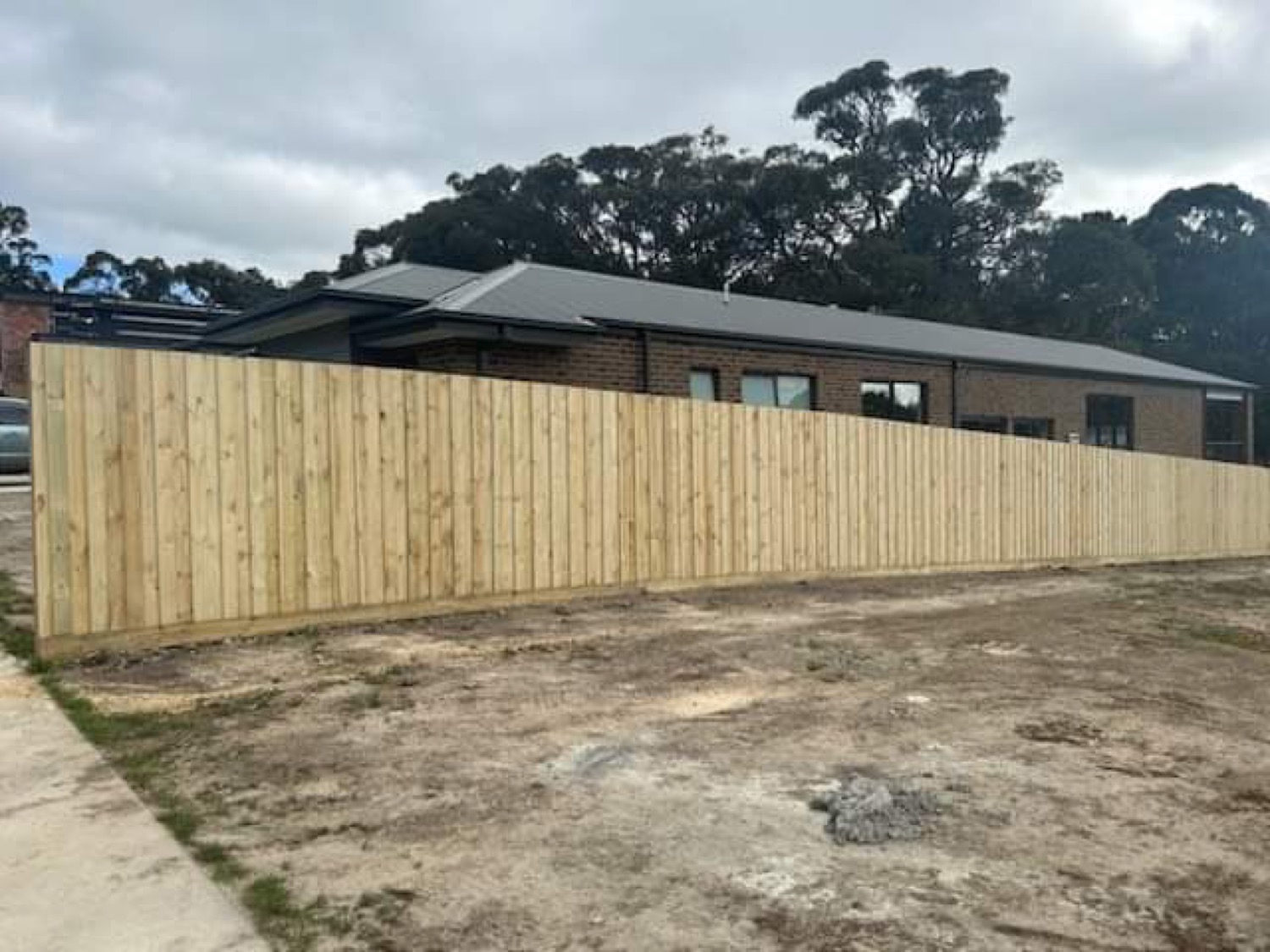 a new timber paling fence along the edge of a cleared block