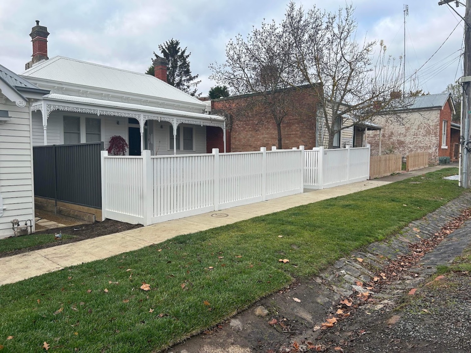 a white picket fence along a footpath