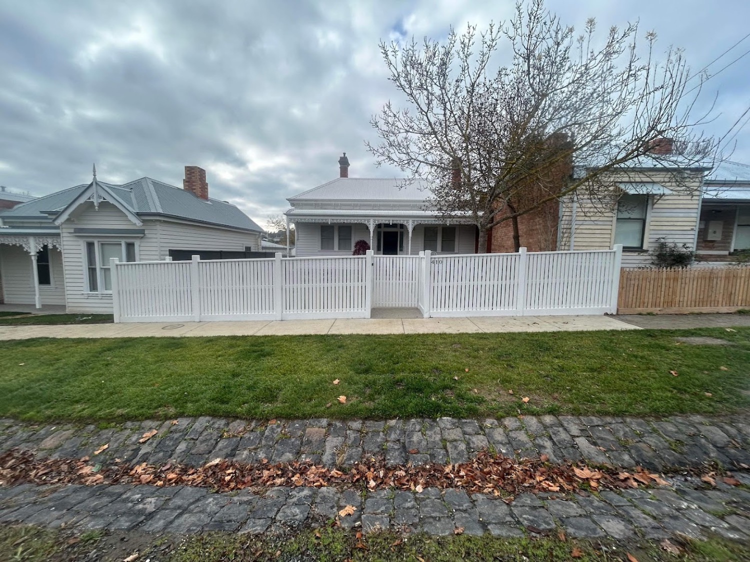 a white picket fence across a front yard