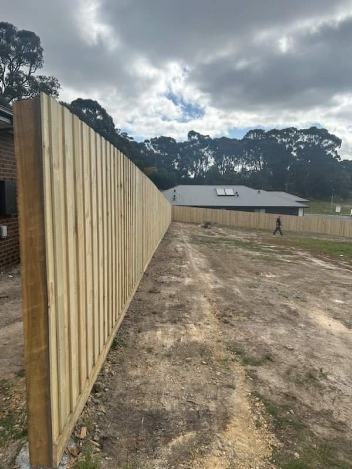 a long timber paling fence along a boundary